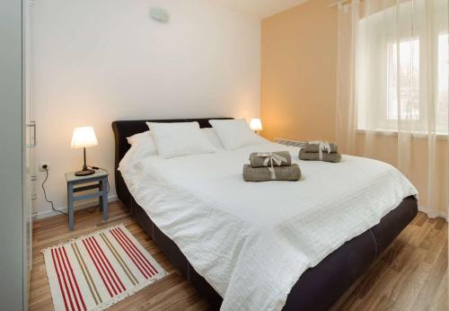 a bedroom with a large bed with two bags on it at First Line Seafront Luxury Apartman Kata in Rogotin
