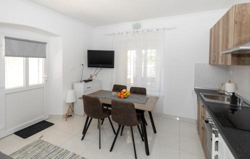 a kitchen with a table and chairs in a room at First Line Seafront Luxury Apartman Kata in Rogotin