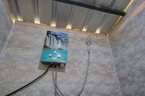 a tv on a wall in a bathroom at Kampoeng Regang By BHATARA in Patengan