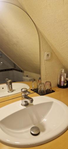 a white sink in a bathroom with a mirror at Chambre d'Hotes Le Vogelgarten in Sigolsheim