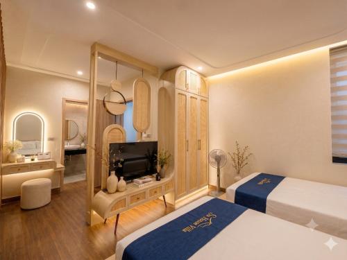 a hotel room with two beds and a television at Su House Villa in Gò Ba Quần