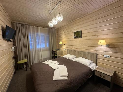 a bedroom with a bed with towels on it at Шале На бе́резі in Kvasy