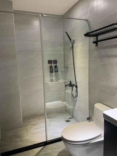 a bathroom with a shower and a toilet at Long Lang Homestay in Tainan