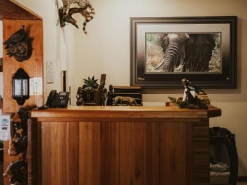 a desk with a picture of an elephant on the wall at Klipspringer Lodge in Nelspruit