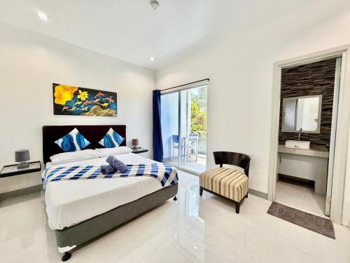 a bedroom with a bed and a chair and a window at Sapphire Boutique Resort in Panglao Island