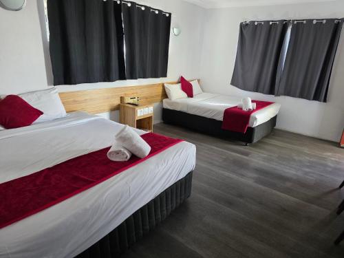 a hotel room with two beds and a table at Emerald Central Hotel in Emerald