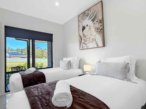 a white room with two beds and a window at Wrenwood in Abernethy