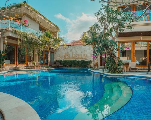 a swimming pool in front of a building at MJ Villa Sanur in Sanur