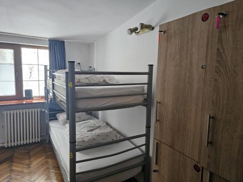 two bunk beds in a small room with a window at HOSTEL SPORT BUCHAREST in Bucharest