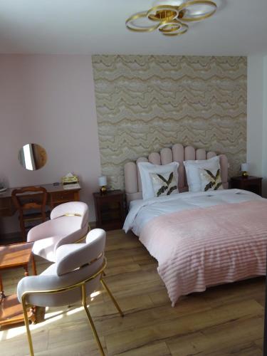 a bedroom with a large bed and two chairs at Les Précieuses in Réaumur