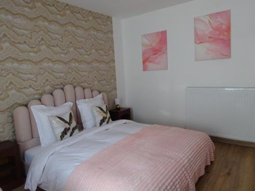 a bed with a pink headboard in a bedroom at Les Précieuses in Réaumur