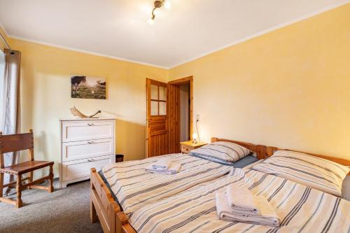 a bedroom with a bed and a chair and a dresser at Cattle Barn - leben auf dem Hof in Tröndel
