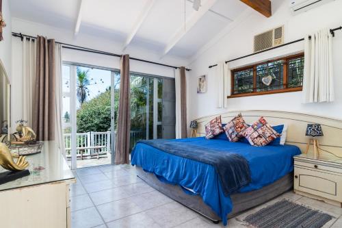 a bedroom with a bed and a balcony at Blue Nautica Coastal Retreat in Ballito
