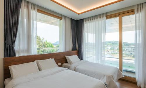 a hotel room with two beds and a large window at Dongho Beach Hotel in Gochang 