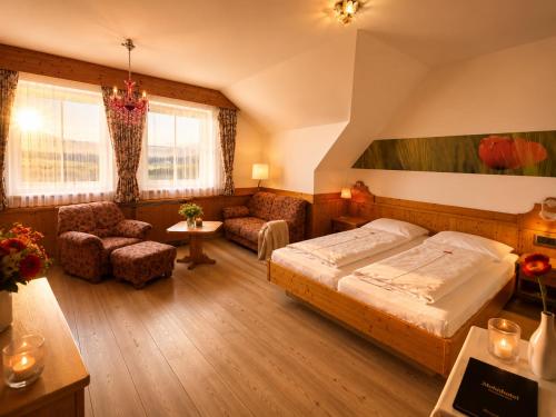 a bedroom with a bed and a living room at Mohnhotel - Bergwirt Schrammel in Zwettl Stadt
