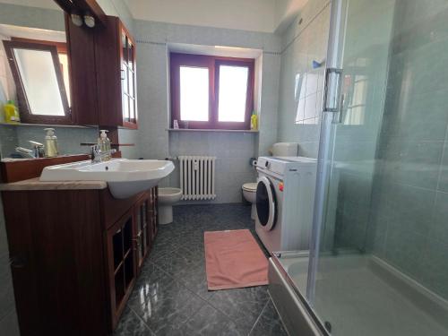 a bathroom with a sink and a washing machine at Da Silvia ampio appartamento metro Paradiso in Collegno