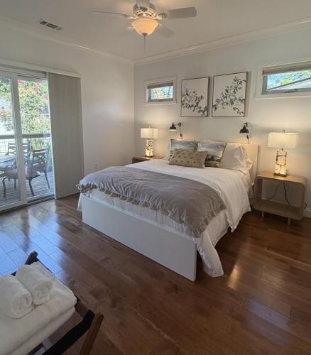 a bedroom with a large white bed with two lamps at Designer Garden Retreat in San Jose