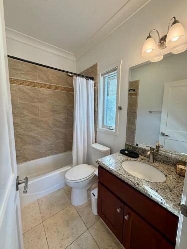 a bathroom with a toilet and a sink and a mirror at Designer Garden Retreat in San Jose