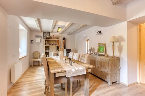 a dining room with a wooden table and chairs at L'écrin de Brévardière in Saint-Pierre-de-Chartreuse