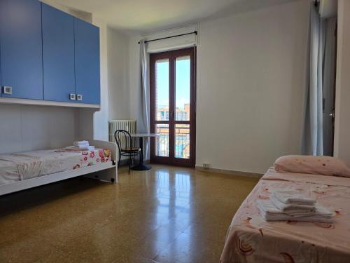 a room with two beds and a door to a balcony at Da Silvia ampio appartamento metro Paradiso in Collegno