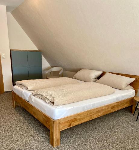a bed with a wooden frame in a room at Heideapartments Hillmer in Bispingen