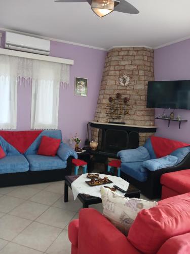 a living room with blue and red furniture and a fireplace at Marry's Guesthouse in Kineta