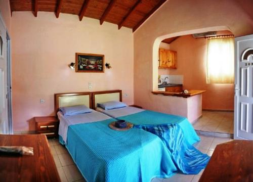 een slaapkamer met 2 bedden en een keuken bij Paradise Studios in Petra