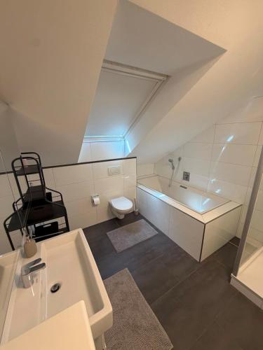 a bathroom with a sink and a tub and a toilet at N90 Living in Karlsruhe