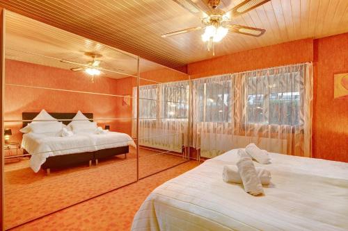 a large bedroom with two beds and a mirror at Sandra in Berghülen