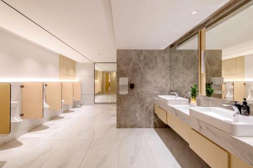 a bathroom with two sinks and a row of mirrors at FOX Lite Hotel Majalaya in Bojong