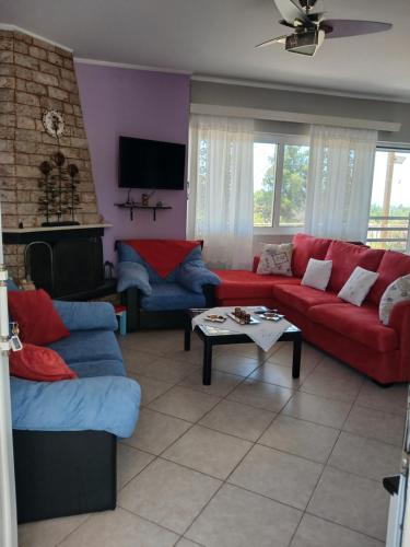 a living room with red and blue couches and a table at Marry's Guesthouse in Kineta