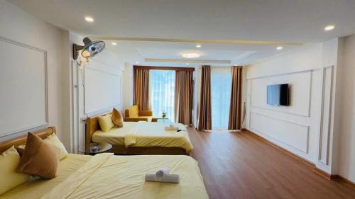 a hotel room with two beds and a television at New Sun Hotel in Da Lat