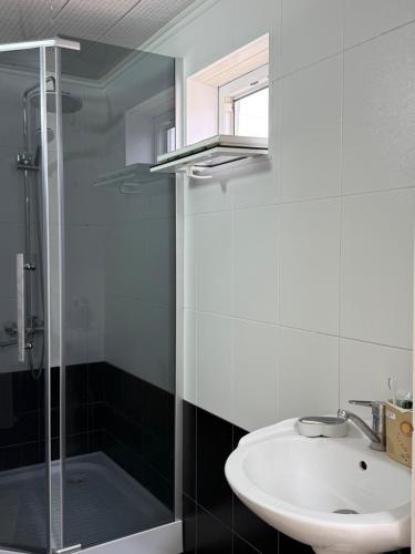 a bathroom with a sink and a shower at Erkaiym Guest house in Bokonbayevo