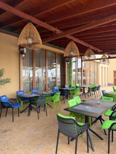 a restaurant with tables and chairs and windows at Hotel Hanul de la Rascruce in Arad