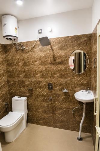 a bathroom with a toilet and a sink and a mirror at Hariom Stay Rishikesh in Rishīkesh