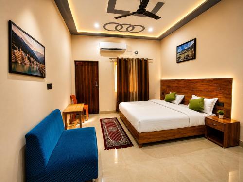 a bedroom with a bed and a blue chair at Hariom Stay Rishikesh in Rishīkesh
