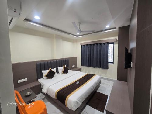 a bedroom with a large bed in a room at Hotel Saffron in Vadodara