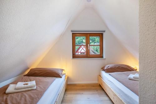 two beds in a room with a window at Ferienhaus Schmuckstück in Schiltach