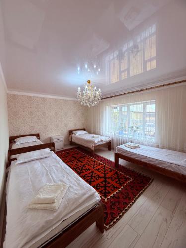 a large room with two beds and a chandelier at Erkaiym Guest house in Bokonbayevo