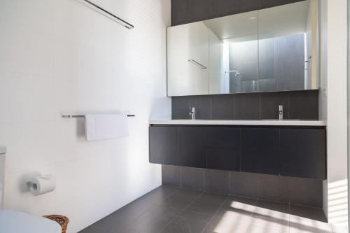 a bathroom with a sink and a mirror at Emanjay - Mineral Spa, Million Dollar Views in Mount Martha