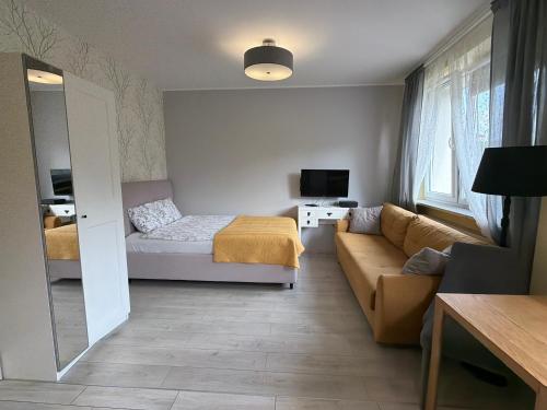a small living room with a bed and a couch at Apartament COMFORT Centrum in Krotoszyn