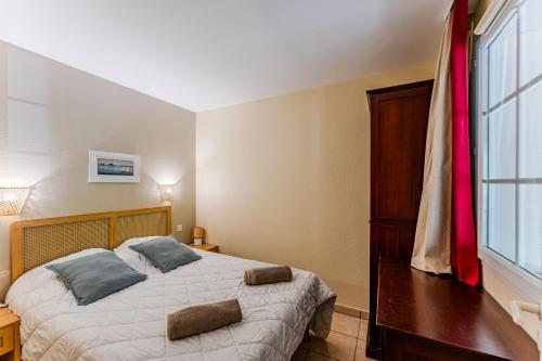 a bedroom with a large bed and a window at Golf de Biscarrosse – Piscine in Biscarrosse