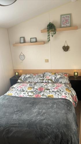 a bedroom with a bed with a comforter on it at Luxury Family Caravan St Osyth Beach Clacton on Sea in Saint Osyth
