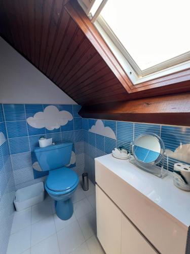 a bathroom with a blue toilet and a sink at Le Clos Colette in Neuvy