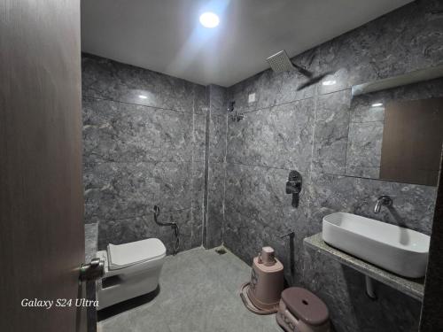 a bathroom with a toilet and a sink at Hotel Saffron in Vadodara