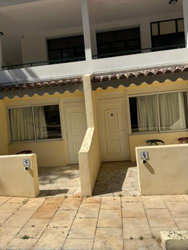 a house with a garage with two benches in front of it at Hôtel Le Robinson in Beaucaire