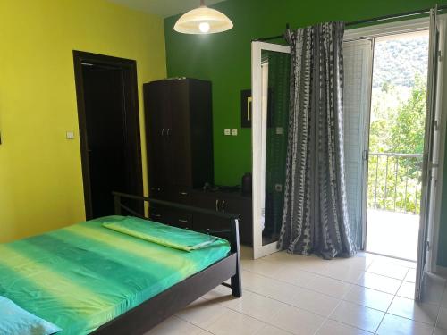 a bedroom with a bed with green walls and a window at Templa in Himare
