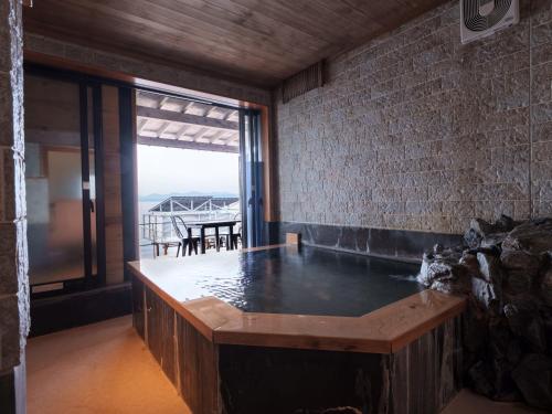 a hot tub in a room with a view of the ocean at Costa Del Sol HIJI in Hiji