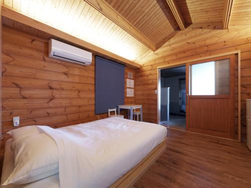 a bedroom with a bed in a wooden wall at Costa Del Sol HIJI in Hiji