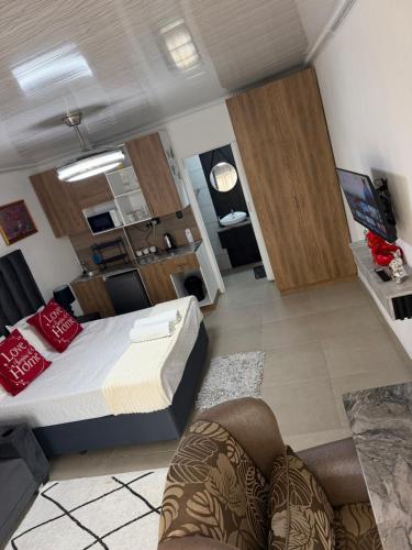 a bedroom with a bed and a living room at Rest Inn C Guesthouse - 10min from OR Tambo Airport in Boksburg